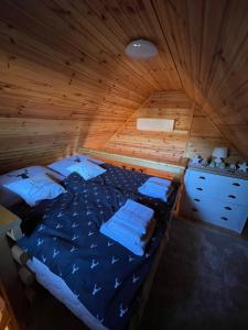 ein Schlafzimmer mit einem Bett in einer Holzhütte in der Unterkunft Hunting Lodge Lipót in Lipót