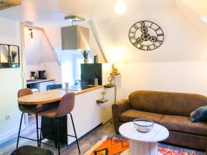 ein Wohnzimmer mit einem Sofa und einem Tisch in der Unterkunft L’INDUSTRIEL en centre ville sur rive du TRIEUX in Guingamp