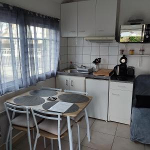uma cozinha com mesa e cadeiras e uma cozinha com balcão em L'Atelier à 100 m de Tarbes sud em Laloubère