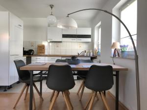 eine Küche mit einem Holztisch und schwarzen Stühlen in der Unterkunft Ferienapartment Alma in Erfurt
