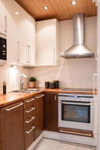 a kitchen with white cabinets and a sink and a stove at Ruka Villa Kieppi in Ruka