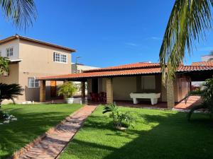 a house with a green lawn and a yard with a table at My House Canoa in Canoa Quebrada