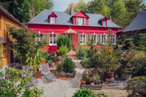 una casa roja con un jardín delante en Au2 Maison d'Hôtes - Guest House Au2, en Muidorge