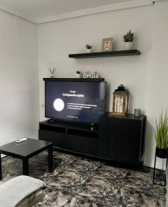 sala de estar con TV de pantalla plana en un soporte en UIM Mediterraneo Juana Wifi, en Puerto Sagunto
