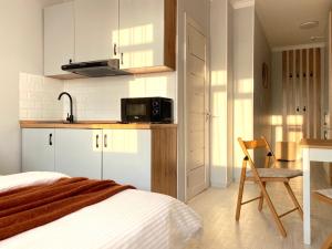 um quarto com uma cama e uma cozinha com um micro-ondas em Skandi em Almaty