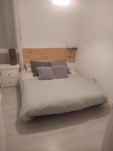 een groot bed in een witte kamer met 2 kussens bij Plena naturaleza en Pleno San Sebastián in San Sebastian
