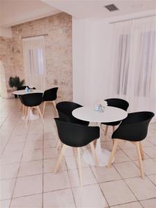 a dining room with black chairs and white tables at Alkyon Hotel in Parikia