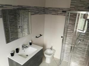 La salle de bains est pourvue de toilettes, d'un lavabo et d'une douche. dans l'établissement Green Relax in Maccagno, à Maccagno Inferiore