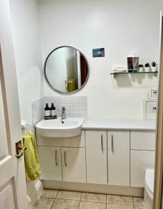 a white bathroom with a sink and a mirror at The Paddock at Peacock Farm near Belvoir Castle in Redmile