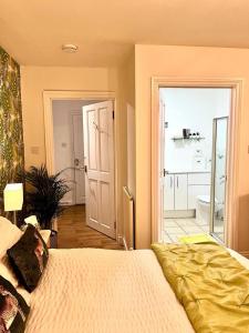 a bedroom with a large bed and a bathroom at The Paddock at Peacock Farm near Belvoir Castle in Redmile