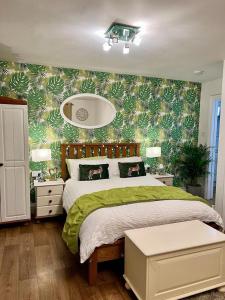 a bedroom with a bed with a green leafy wall at The Paddock at Peacock Farm near Belvoir Castle in Redmile