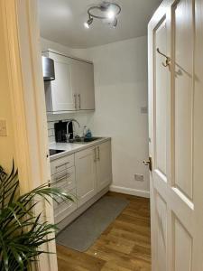 a kitchen with white cabinets and a counter top at The Paddock at Peacock Farm near Belvoir Castle in Redmile