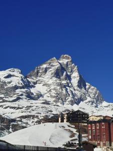 a building in front of a snow covered mountain at Home ON SLOPES, the slope n°3 is under the balcony! in Breuil-Cervinia