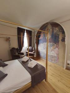 een slaapkamer met een bed en een groot schilderij aan de muur bij San Pier Novello in Oltrarno in Florence