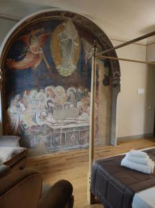 - une chambre avec une fresque murale d'un lit et un canapé dans l'établissement San Pier Novello in Oltrarno, à Florence