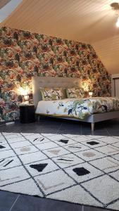 a bedroom with a bed with a floral wall at Les Korrigans in Tréméven
