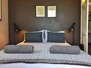 a bedroom with a large bed with two pillows on it at The Old School House in Calitzdorp