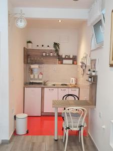 Studio Apartment CONTE Split في سبليت: مطبخ صغير مع طاولة وكراسي