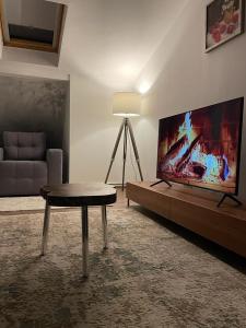 a living room with a tv and a table and a couch at Sofia Loft in Bistriţa