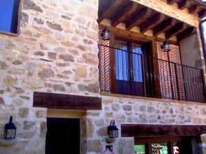 um edifício com duas janelas e uma varanda em La Hijuela em Navafría