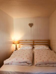 a bed with two pillows and a heart on the wall at Ferienwohnung Josefine in Niedergesteln