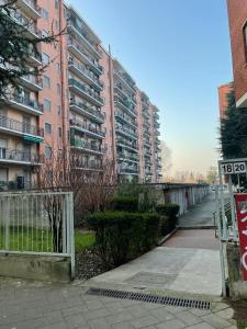 duży budynek apartamentowy z znakiem przed nim w obiekcie Kibilù - San Donato vicinanze IRCCS Policlinico w mieście San Donato Milanese
