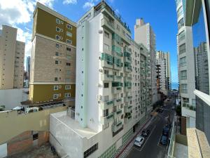 een hoog wit gebouw in een stadsstraat bij WAL51 - Churrasq, Quadra Mar, 3 Dorm, Climatizado in Balneário Camboriú