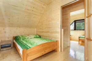 a wooden cabin with a bed in a room at Holiday complex, Pobierowo in Pobierowo