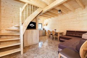 a living room with a couch and a staircase in a log cabin at Holiday complex, Pobierowo in Pobierowo