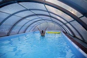 a woman swimming in a pool in an indoor swimming pool at Holiday resort, Wiselka in Wisełka