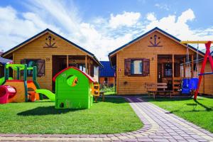 a playground in front of two wooden houses at Holiday resort, Wiselka in Wisełka