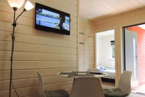 a room with a table and a tv on a wall at Bungalow, Kolczewo in Kołczewo