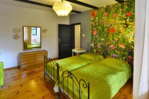 um quarto com uma cama verde e uma parede de flores em holiday home, Polanow em Pollnow