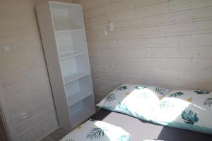 ein Schlafzimmer mit einem Bett und einem weißen Schrank in der Unterkunft Bungalow in Kolczewo near Baltic Sea in Kołczewo + 4 Fotos