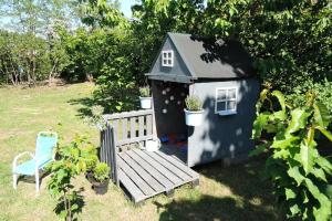 ein kleines Spielhaus mit einer Bank und einem Stuhl in der Unterkunft Bungalow in Kolczewo near Baltic Sea in Kołczewo