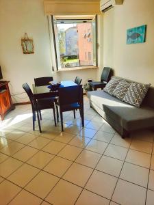 a living room with a bed and a table and chairs at LA STELLA DEL MARE in Marina di Grosseto