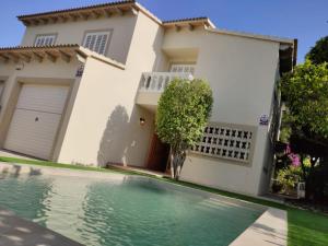 a house with a swimming pool in front of a house at Villa Eden Alcudia, near the beach with pool in Alcudia