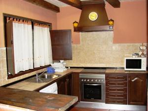 una cocina con fregadero y microondas en La Hijuela, en Navafría