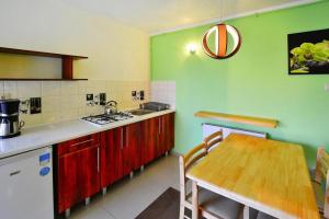 a kitchen with a wooden table and a kitchen with green walls at Semi-detached houses, Sarbinowo in Sarbinowo
