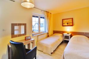a bedroom with two beds and a desk and a window at Terraced House in Grzybowo near Beach in Grzybowo