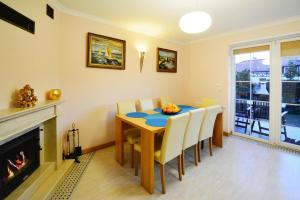 a dining room with a table and a fireplace at Terraced House in Grzybowo near Beach in Grzybowo
