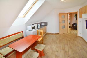 a kitchen and dining room with a table in a attic at Apartments, Sarbinowo in Sarbinowo