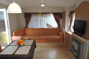 ein Wohnzimmer mit einem Sofa und einem Tisch mit Obst darauf in der Unterkunft Bungalow, Mrzezyno in Mrzeżyno