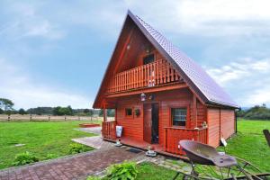 een klein houten huis met een groen veld erachter bij holiday home, Swiecianowo 