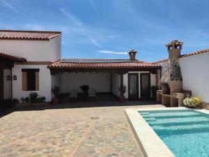 a house with a swimming pool in front of it at LA CASA DE ELENA in Villarrubia de los Ojos