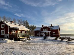 a barn and a house in the snow at Backes Lillstuga in Borlänge