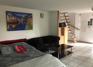 a living room with a couch and a painting on the wall at Entre ville & campagne (jardin avec rivière) in Plobsheim