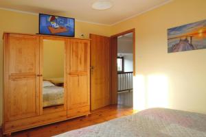 a bedroom with a wooden cabinet with a television on it at Semi-detached house, Miedzyzdroje in Międzyzdroje