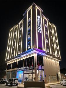 a large building with lights on it at night at مواسم للأجنحة الفندقية in Al Kharj