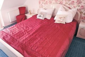 a bedroom with a large red bed with white pillows at holiday home, Nowe Warpno in Nowe Warpno